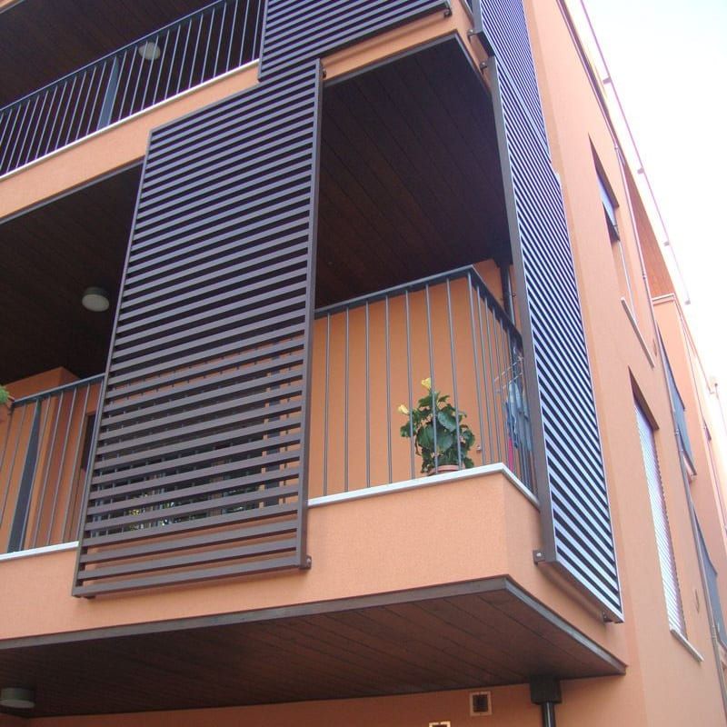 Frangisole in alluminio sui balconi di una facciata condominiale — Forlì