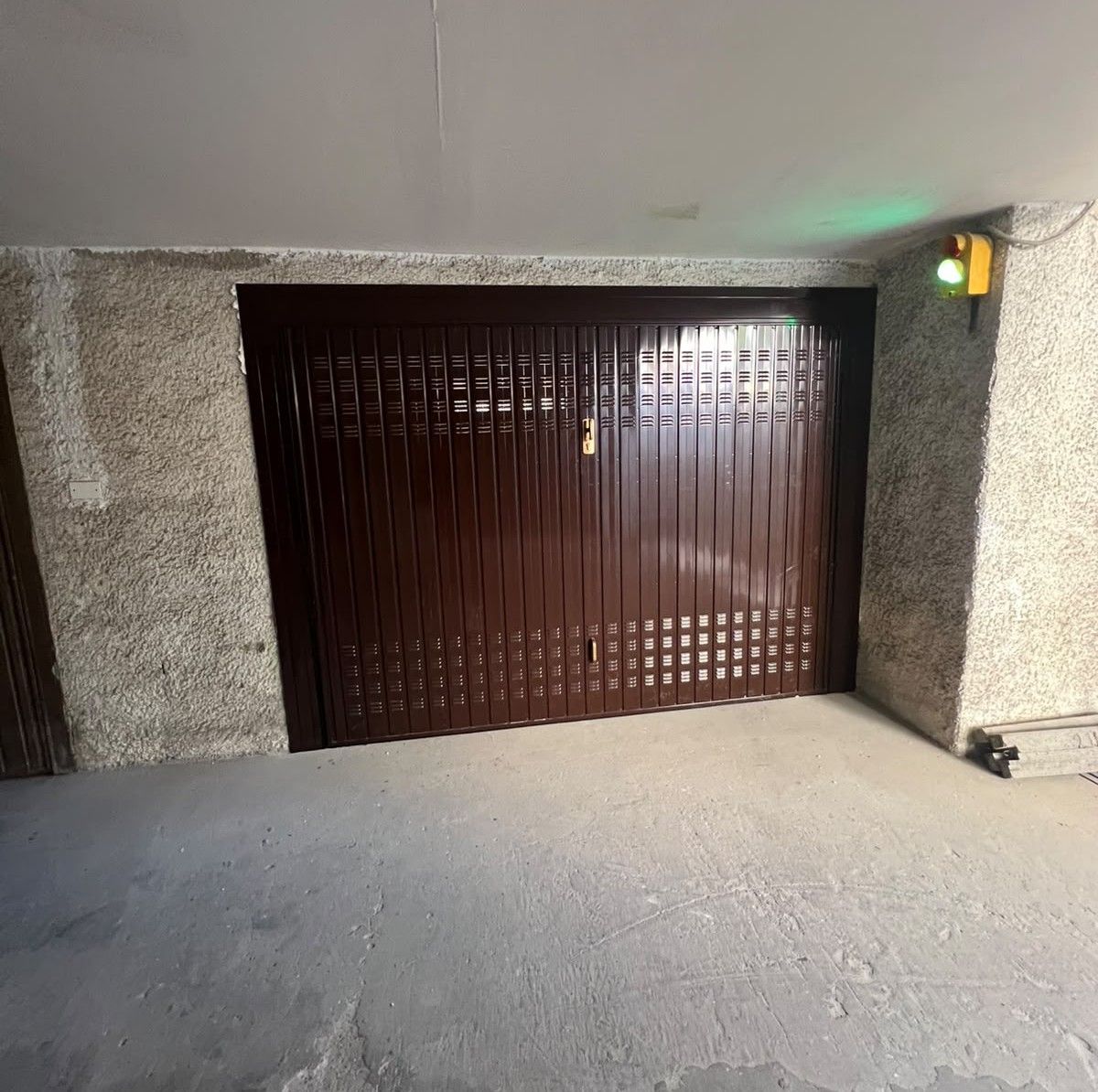 Portone da garage basculante marrone, con le aperture per far passare l’aria